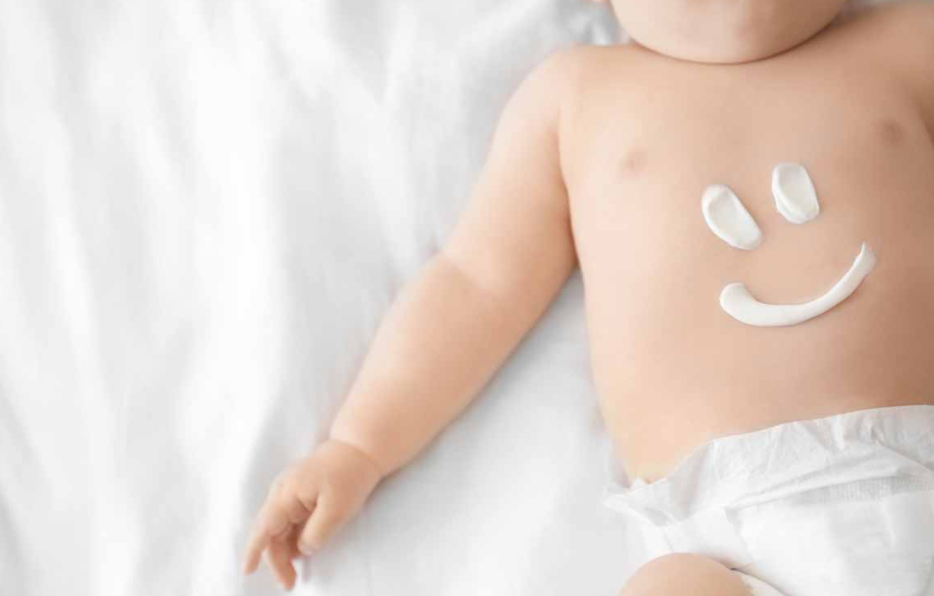 bebé con crema en el abdomen